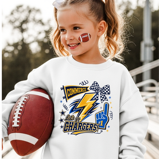Child wearing a white sweatshirt with 'Commerce Chargers' design, holding a football.