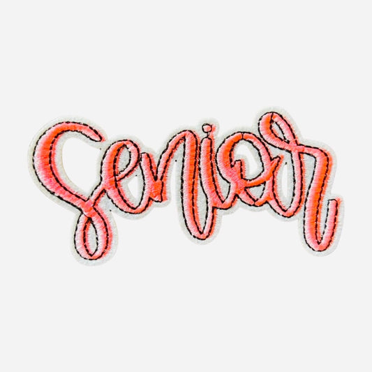May include: A pink embroidered patch with the word &#39;Senior&#39; in a cursive font.